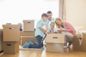 Family unpacking cardboard boxes at new home